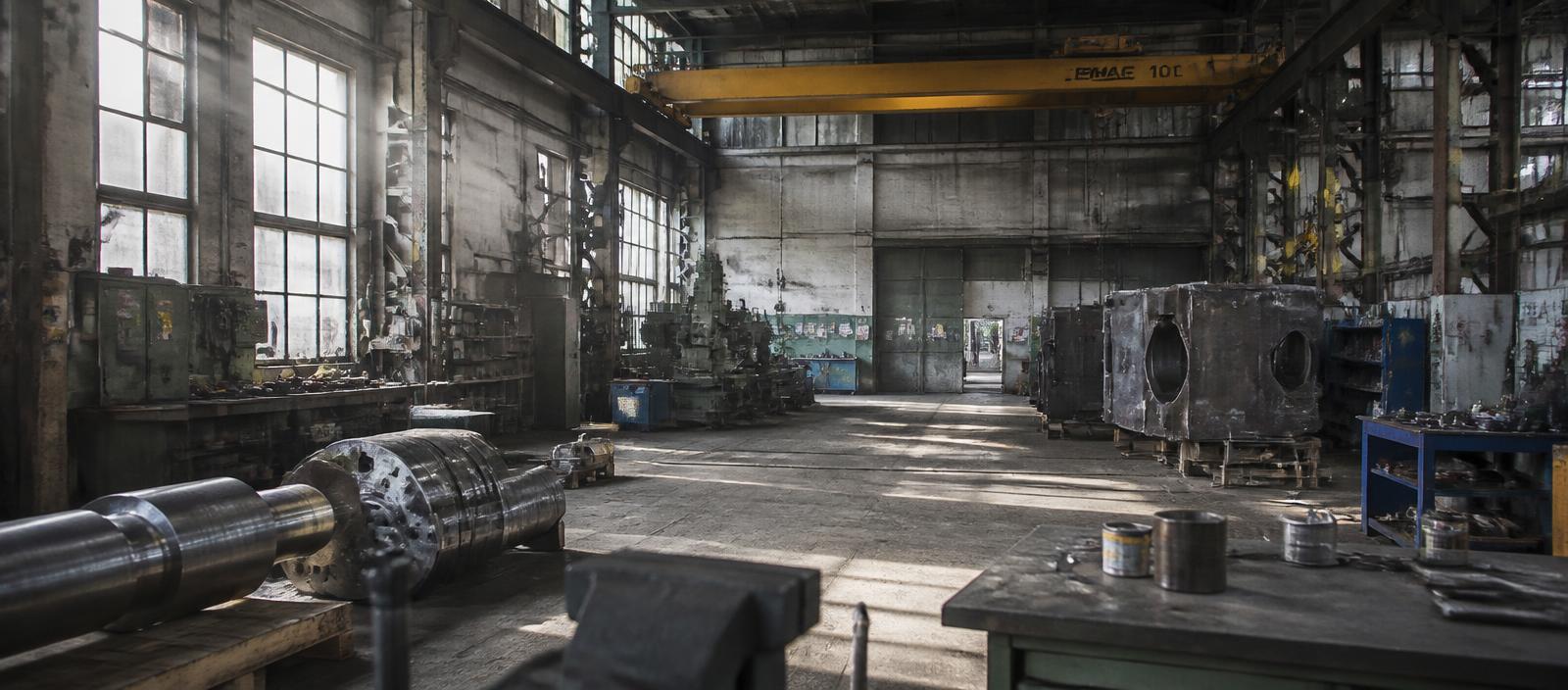 Industrial workshop interior with fabrication equipment and overhead crane
